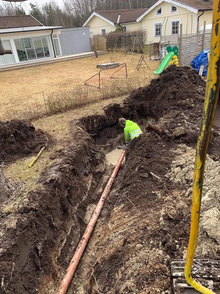 Grävt dike med dräneringsrör längs en villa
